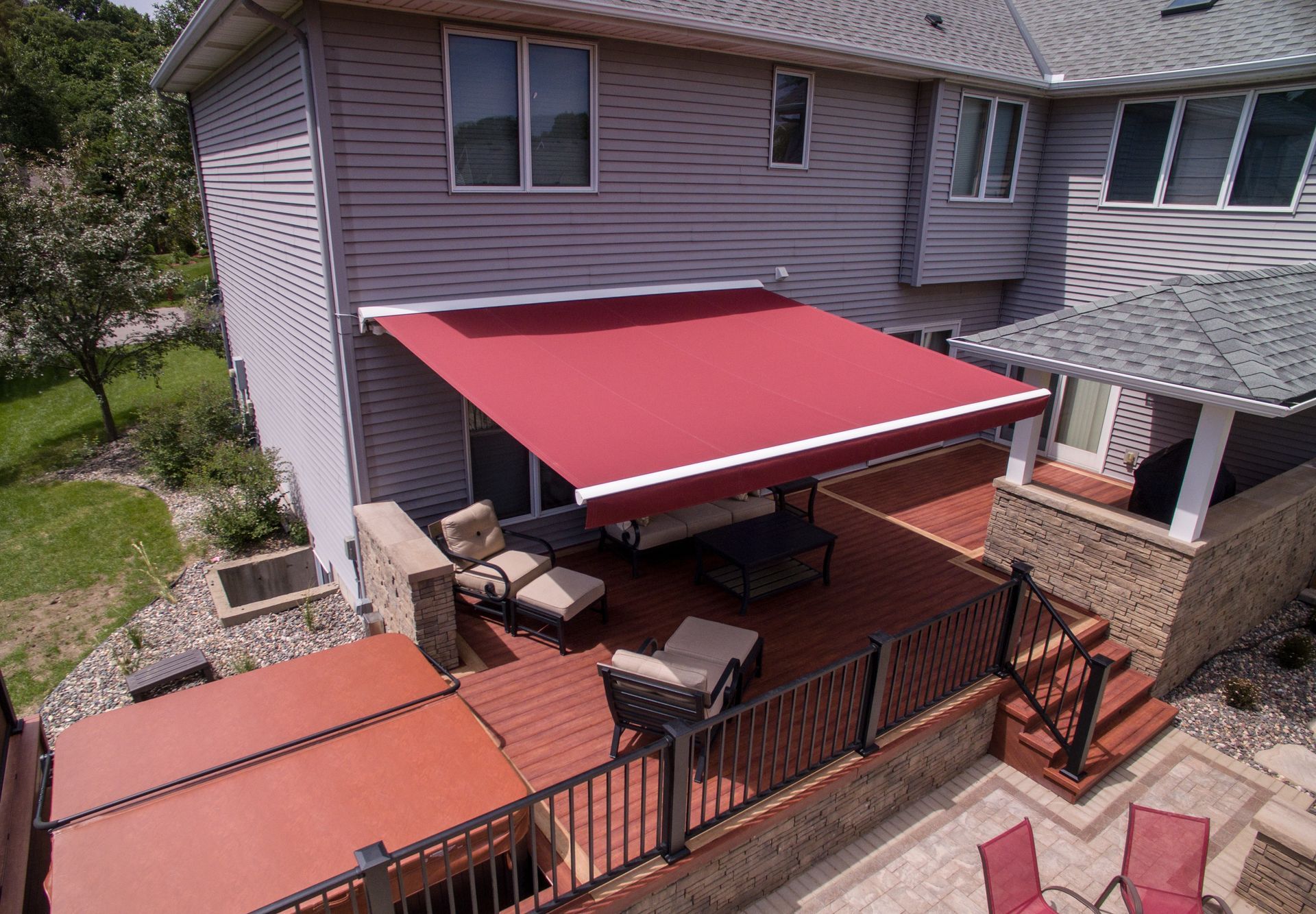 An aerial view of a house with a red awning on the deck.