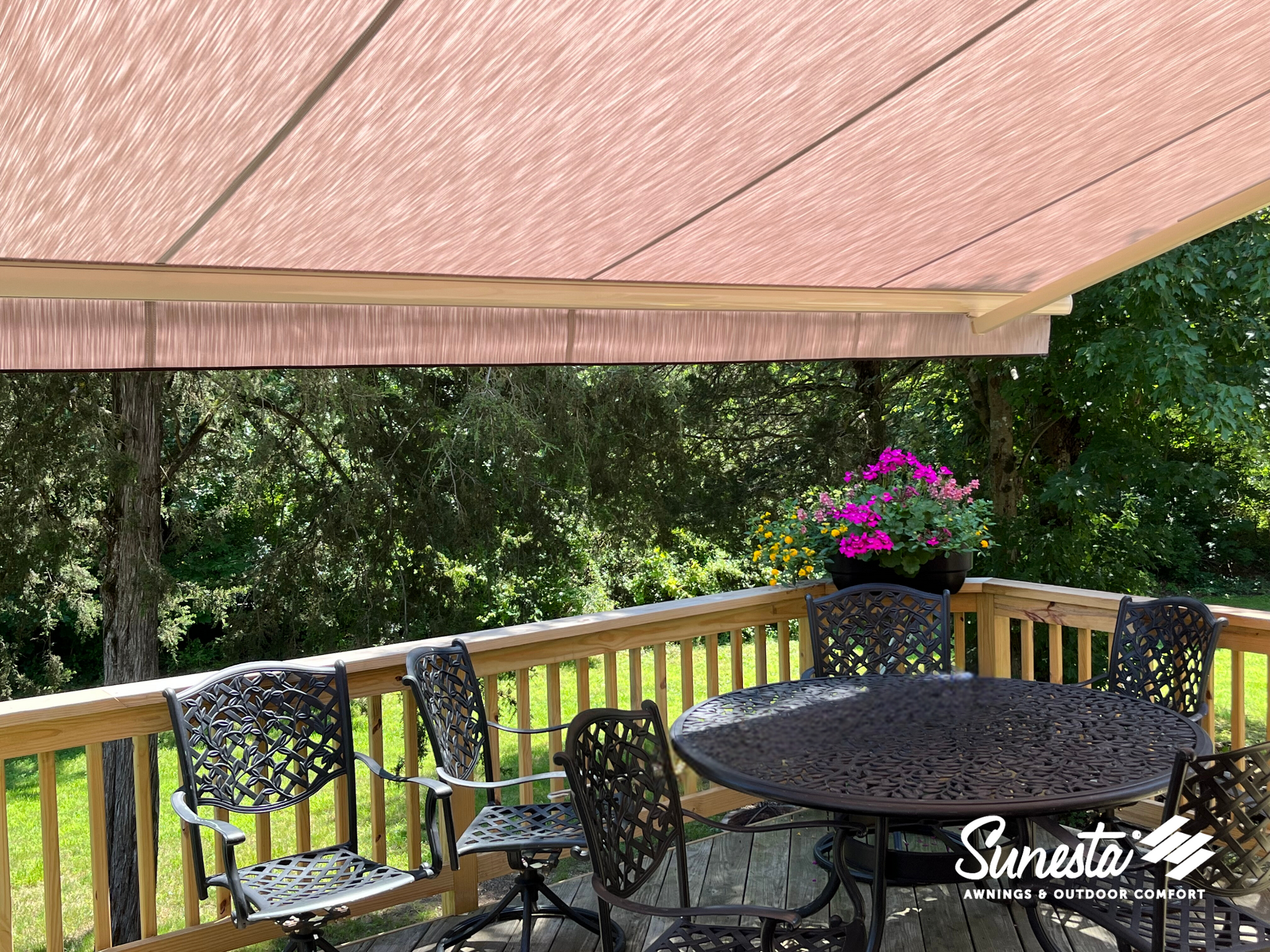 A deck with a table and chairs under an awning.