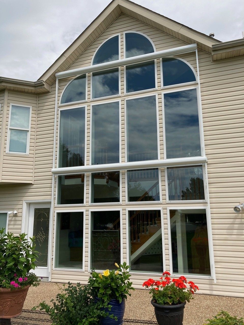 A large house with a lot of windows and flowers in front of it