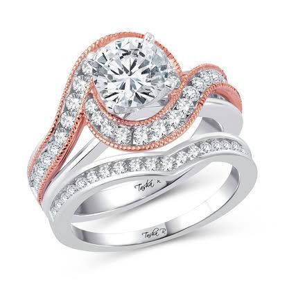 Two-tone engagement ring set with a large, round diamond and smaller accent diamonds on a wavy band.