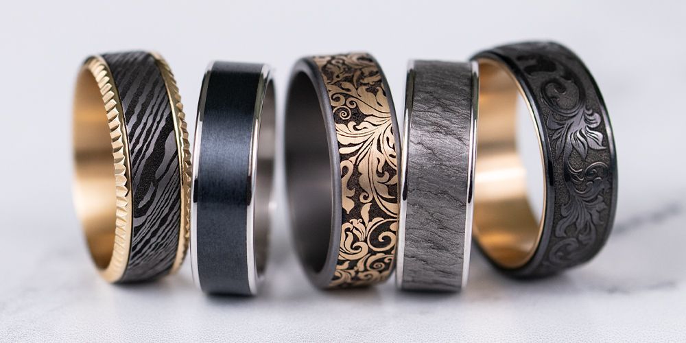 Five ornate rings of various designs and colors displayed.