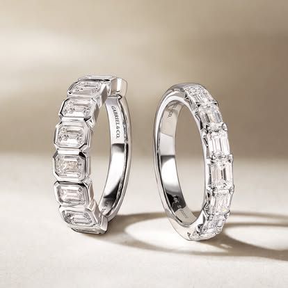 Two white gold rings with emerald-cut and baguette diamonds.