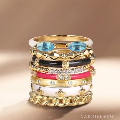 Stack of colorful enamel and gold rings.