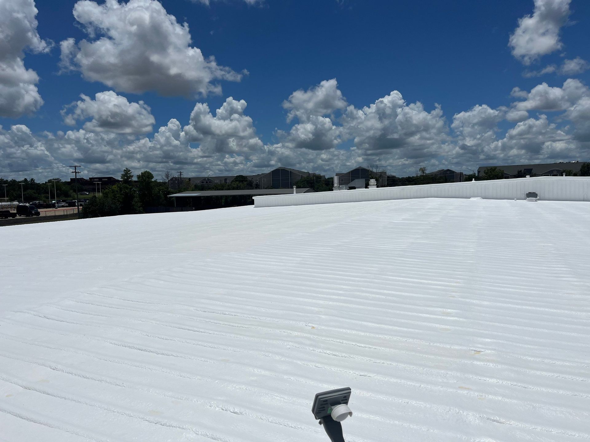 A white roof with a blue sky and clouds in the background.
