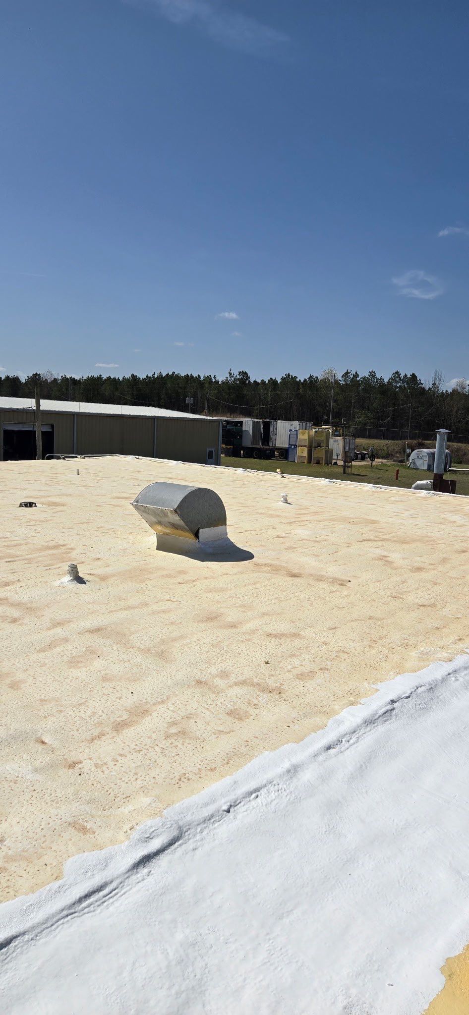 The roof of a building is being painted white.