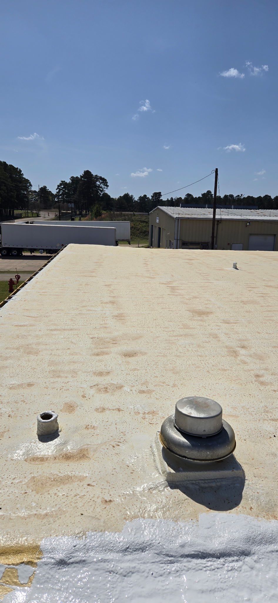 A roof with a fan on it and a blue sky in the background.
