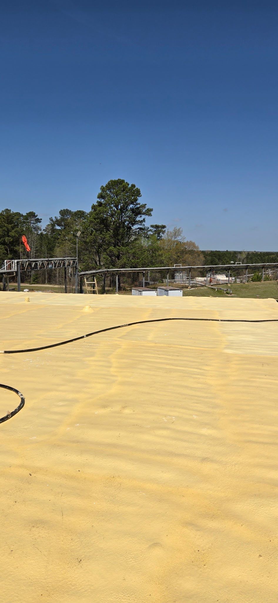 A large empty field with a blue sky in the background.