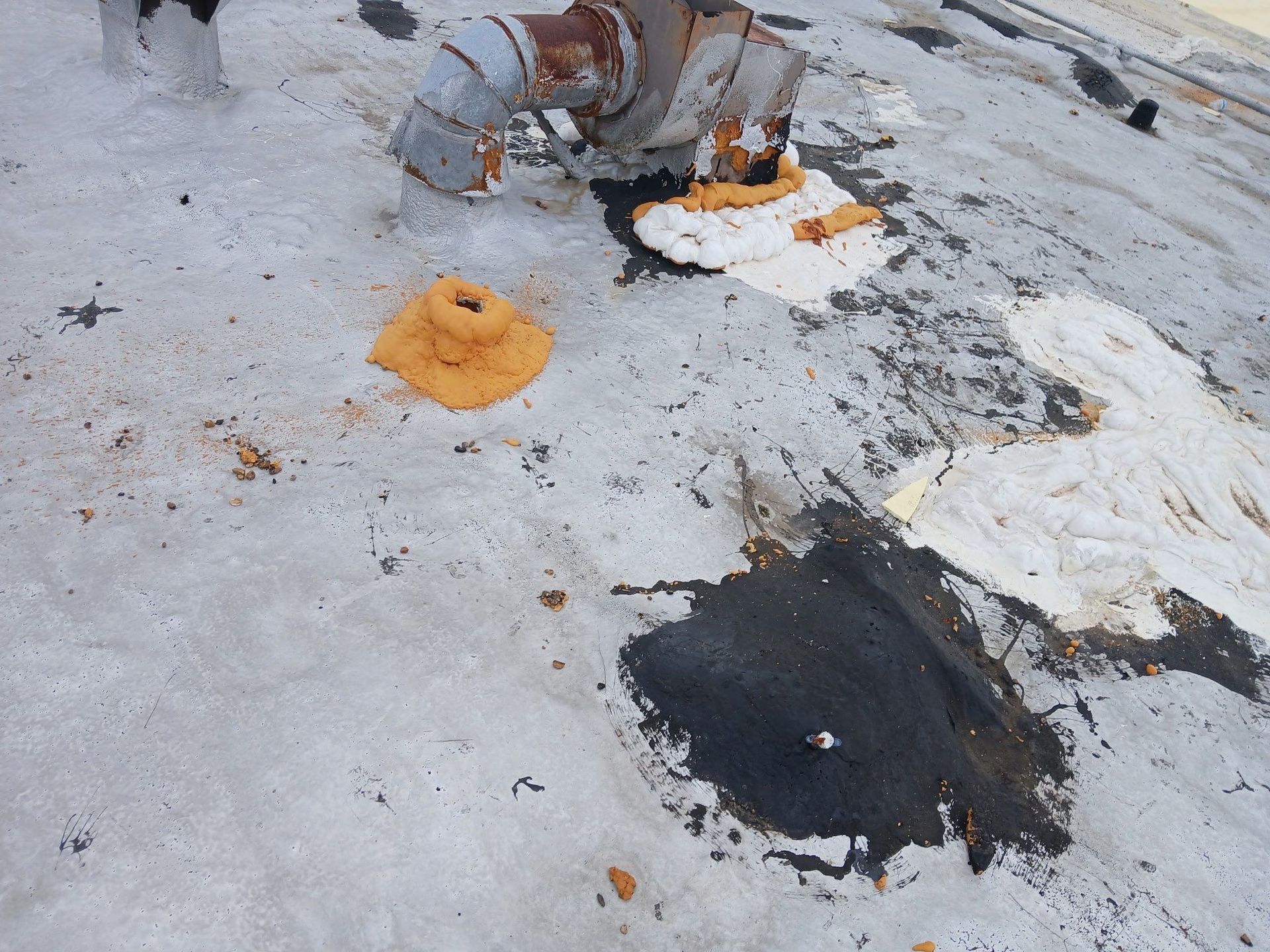 A dirty roof with a pipe and a hole in it.