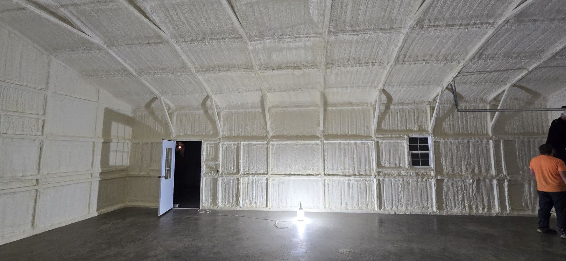 A man is standing in an empty room with a lot of foam on the walls and ceiling.