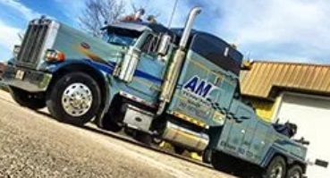 Blue and silver tow truck on a slight incline, with 