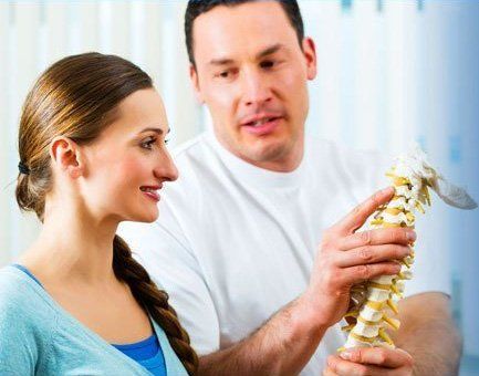 doctor explaining the spine to patient in medical office