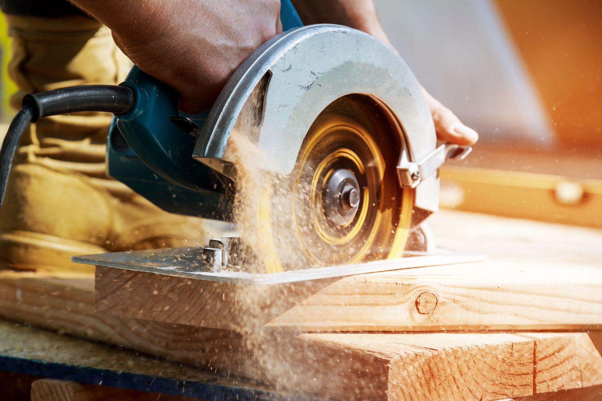 A person is using a circular saw to cut a piece of wood.