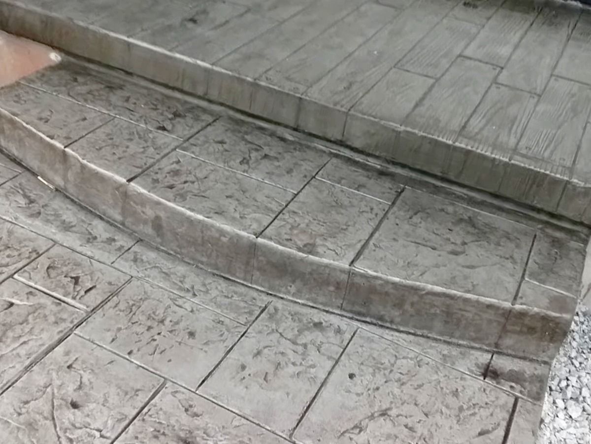 Concrete steps with a curved front, textured to resemble brick and wood.