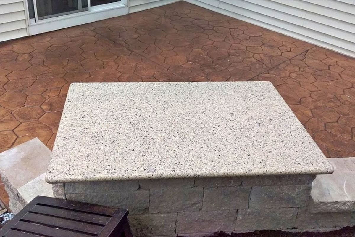 Stone patio with a textured countertop and steps.