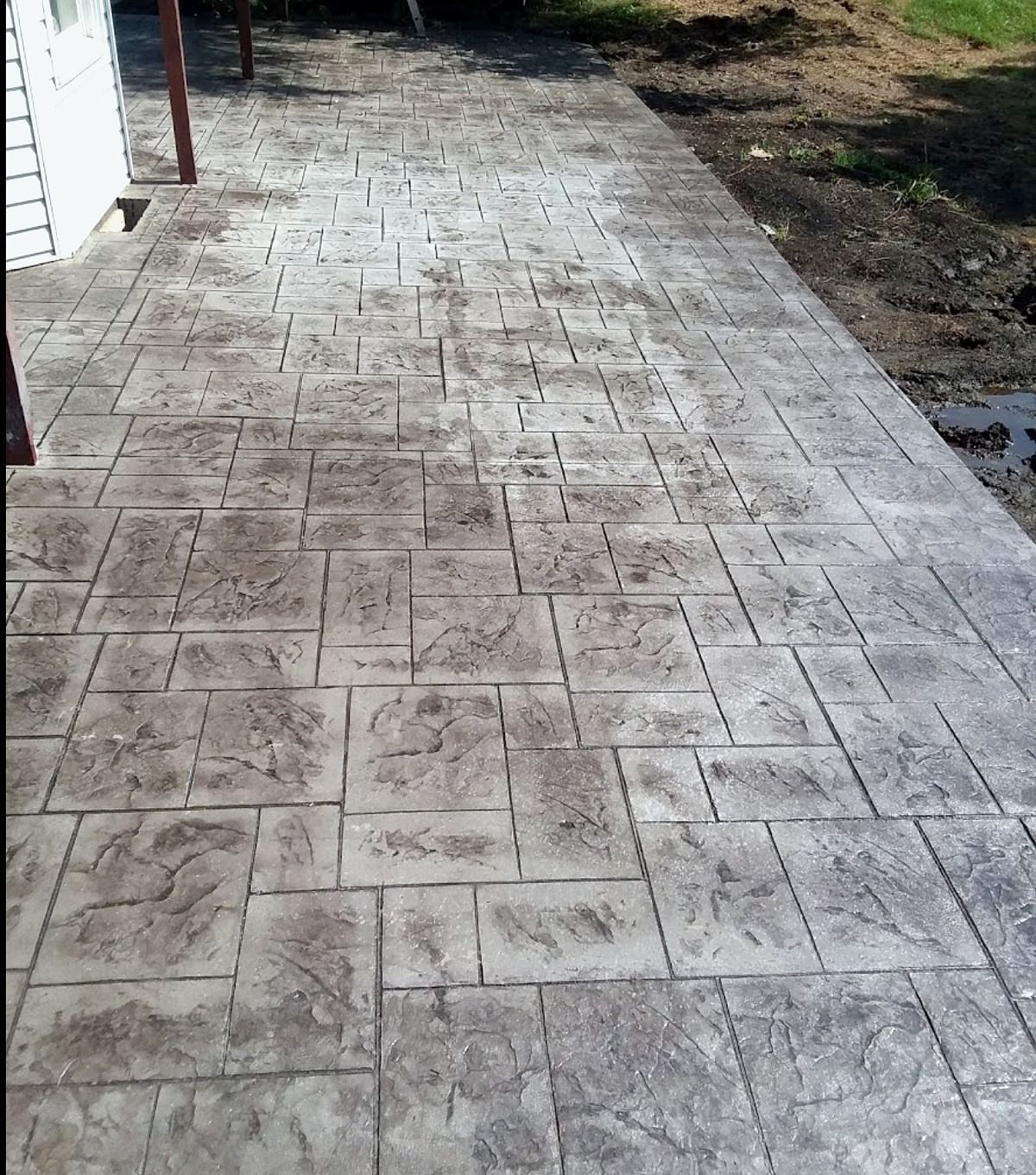 Stamped concrete walkway with gray stone pattern.