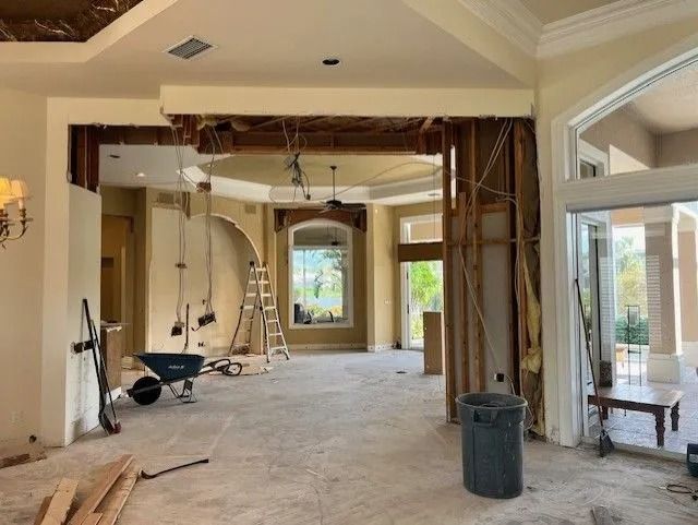 Interior demolition of a home, revealing wall studs and exposed electrical wiring.