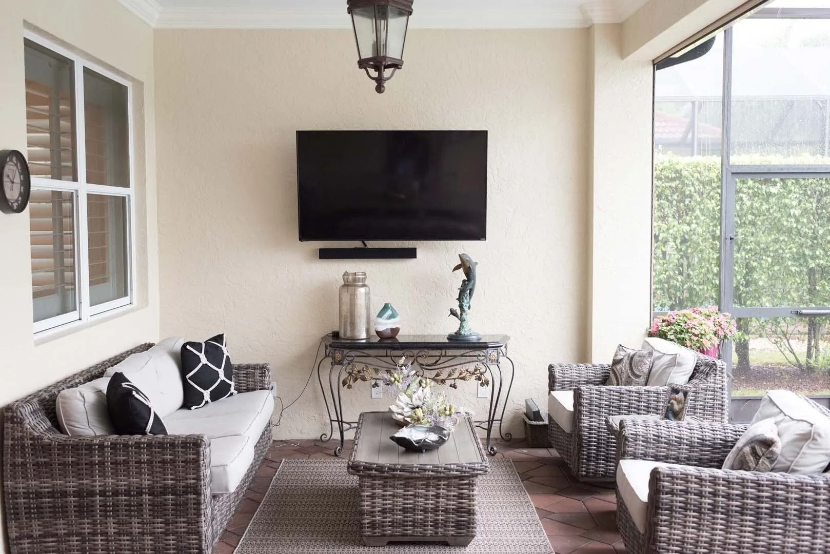 Patio living room with wicker furniture, a TV, and a coffee table.