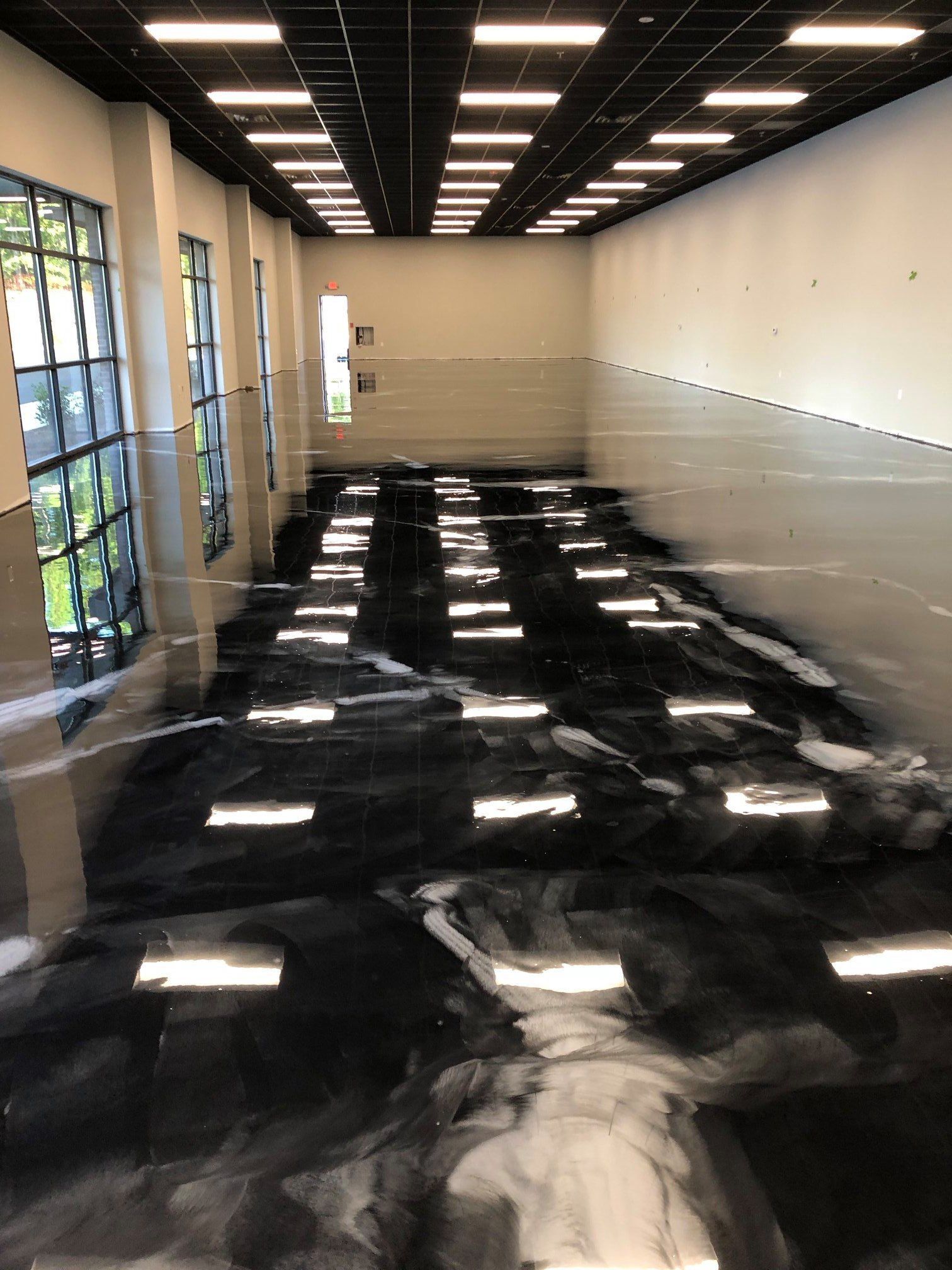 A large room with a lot of windows and a black and white floor.