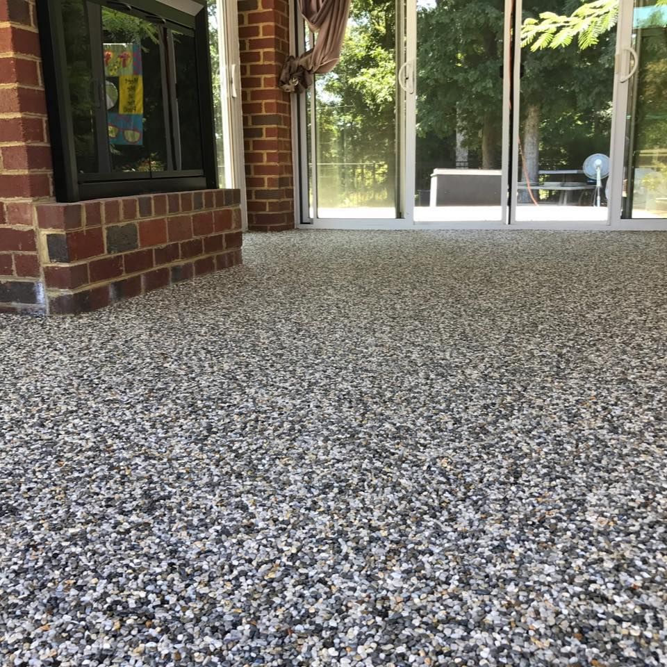 A living room with a brick fireplace and a gravel floor.