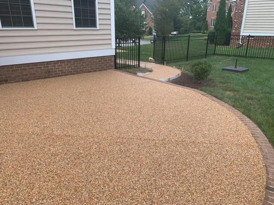 A driveway with gravel and bricks in front of a house.