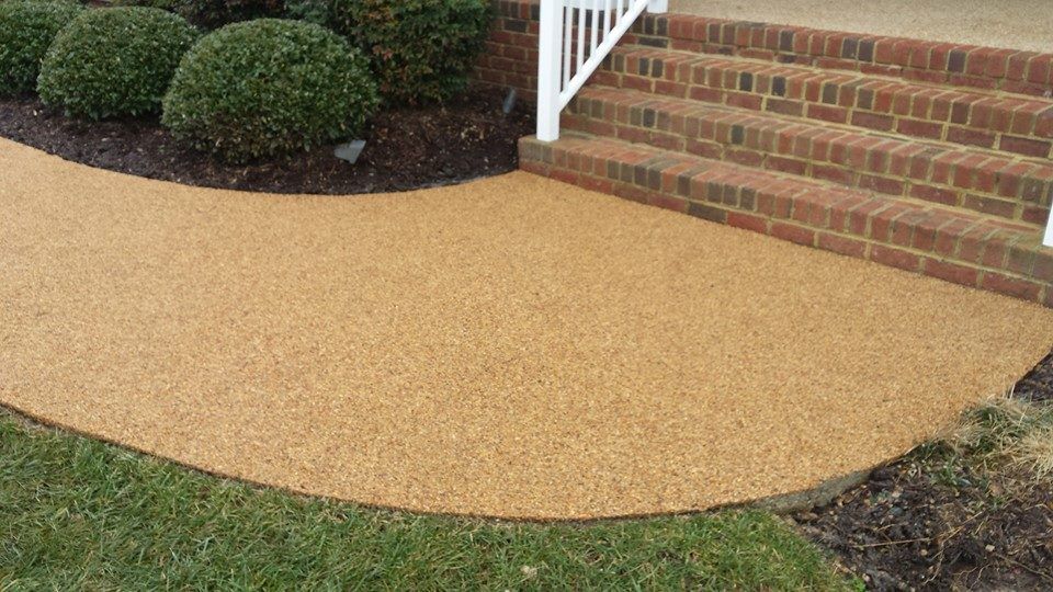 A walkway leading to a brick house with stairs.