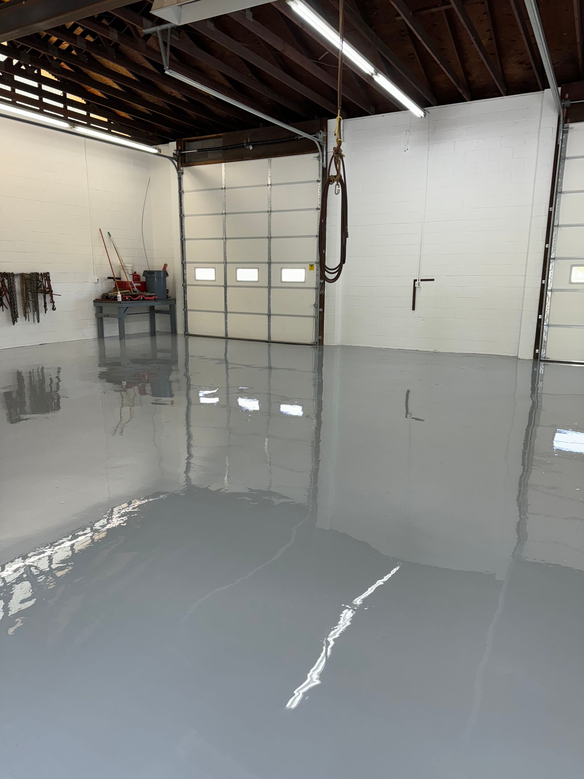 A garage with a gray floor and a garage door.