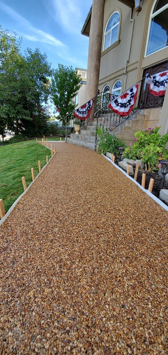 A walkway leading to a house with flags on the side of it.