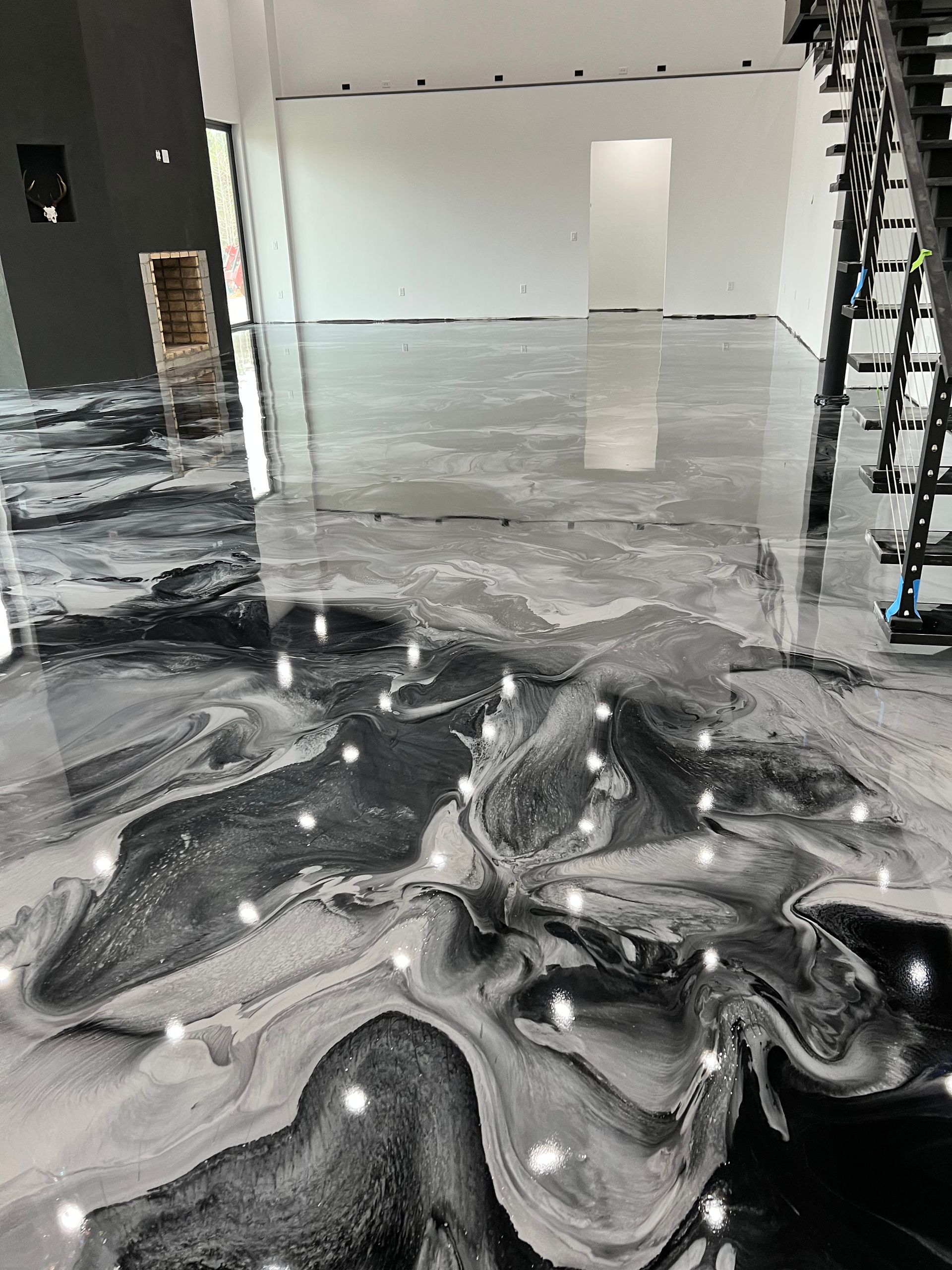 A black and white marble floor with a staircase in the background.