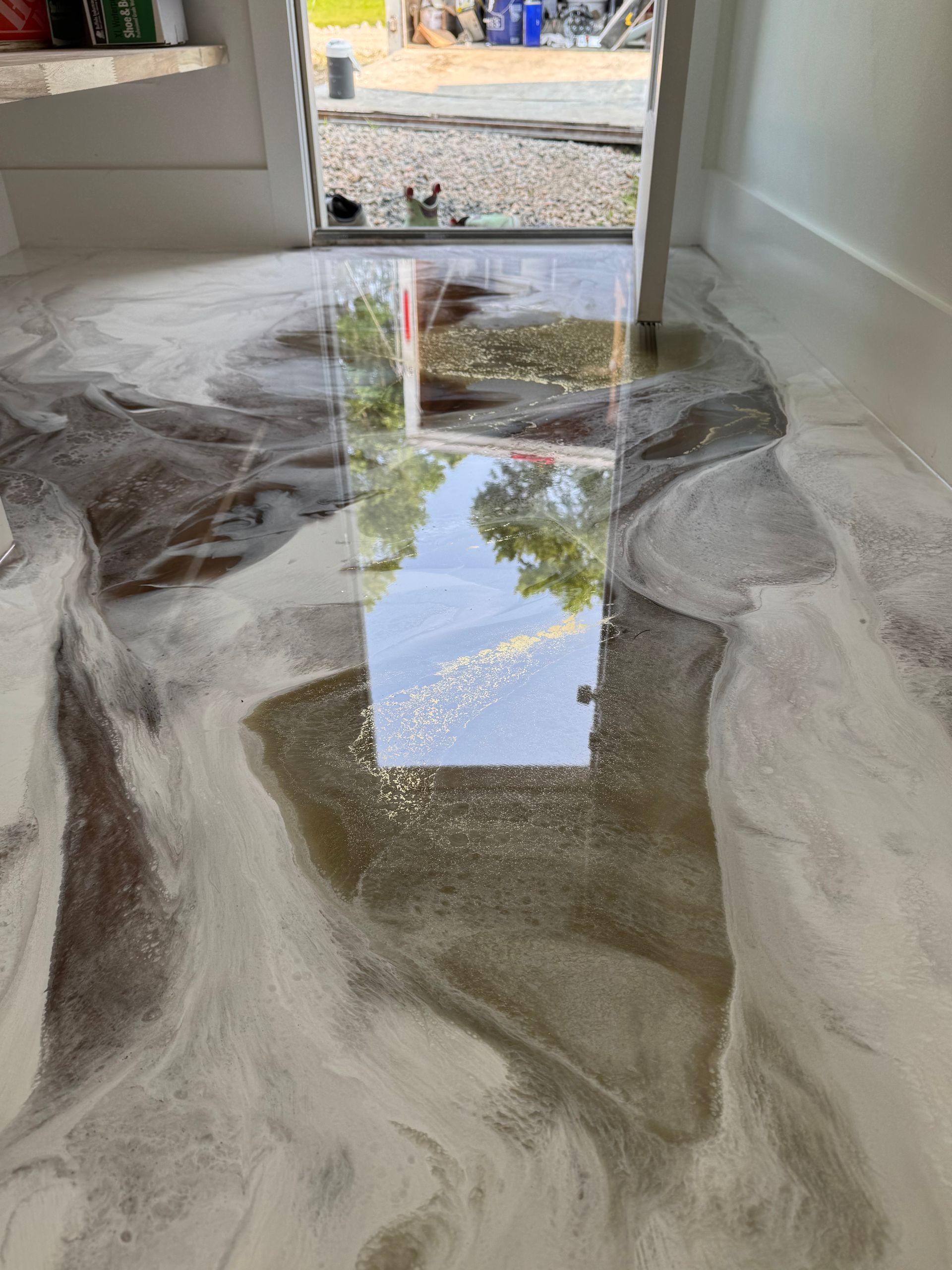 A marble floor with a reflection of a window in it.