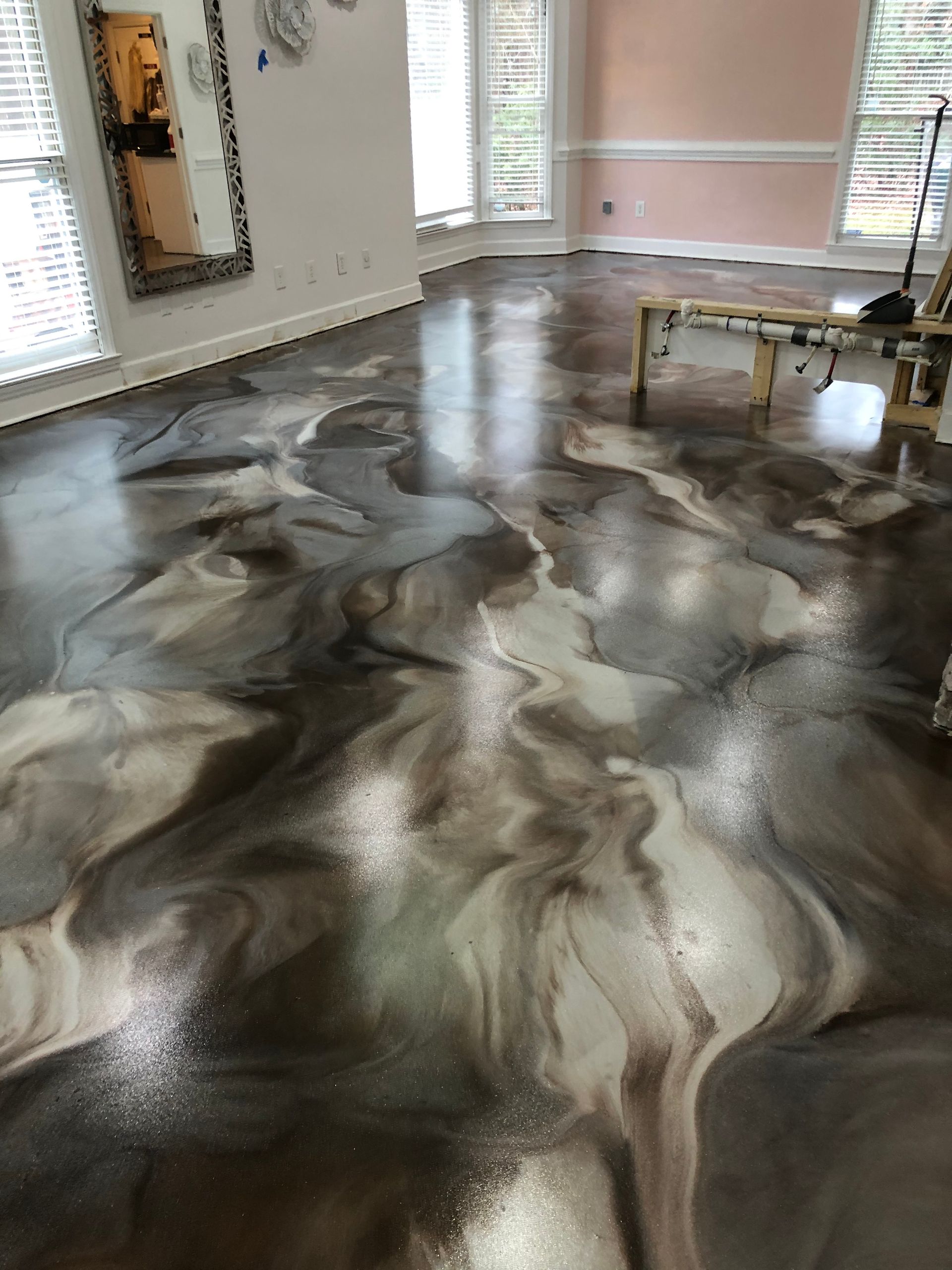 A living room with a marble floor and a mirror.