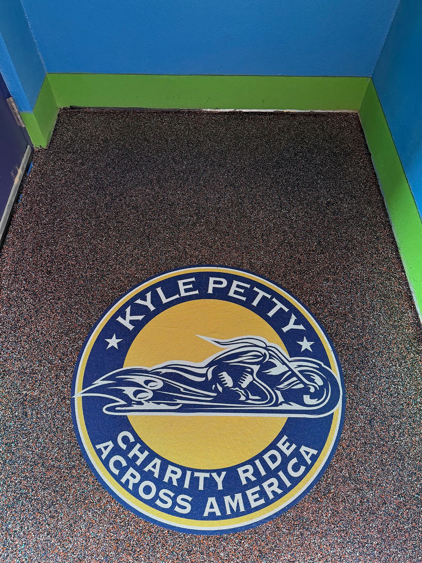 A logo for the Kyle Petty Charity Ride Across America is on the floor.