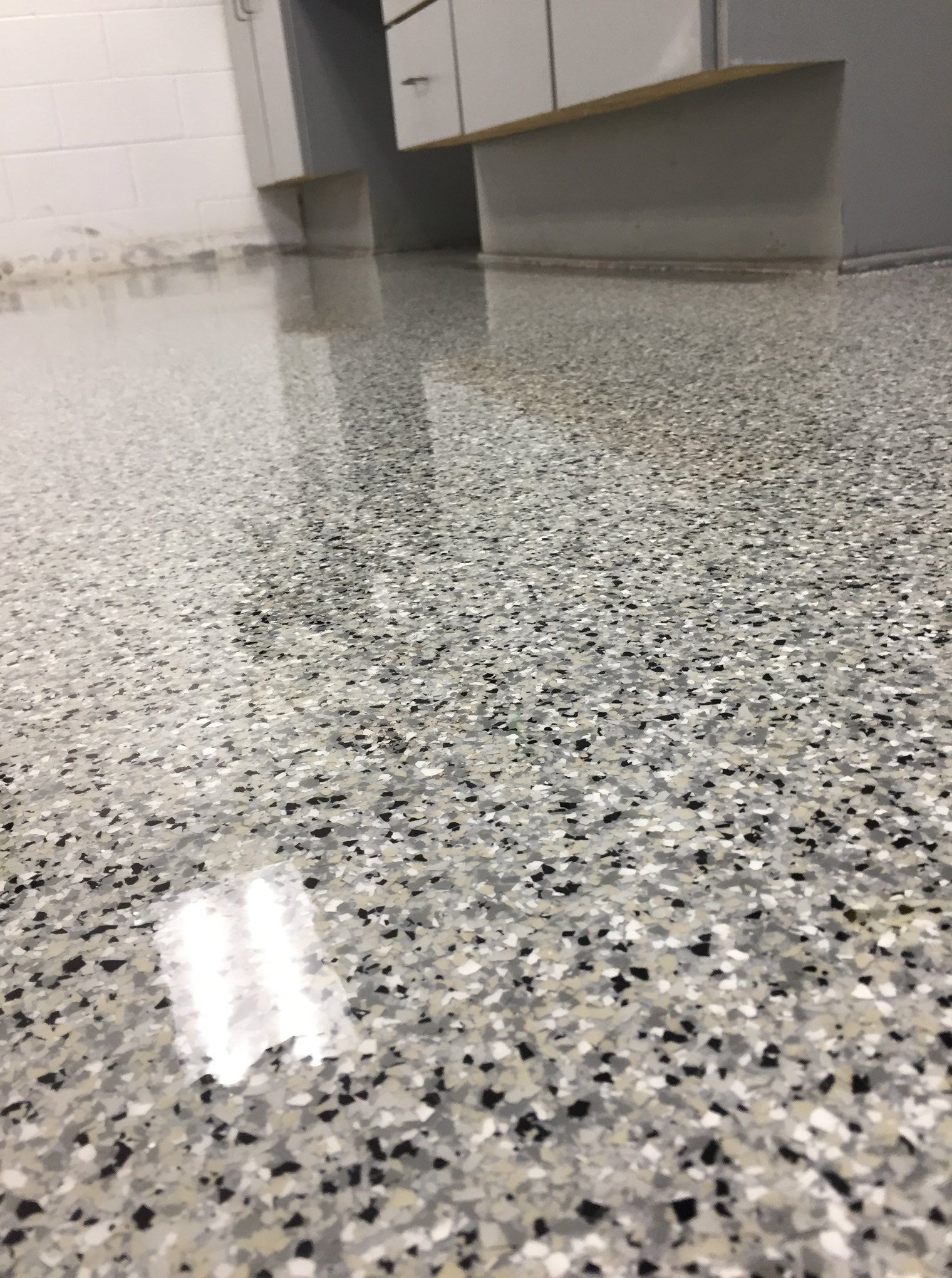 A close up of a gray and black floor in a kitchen.