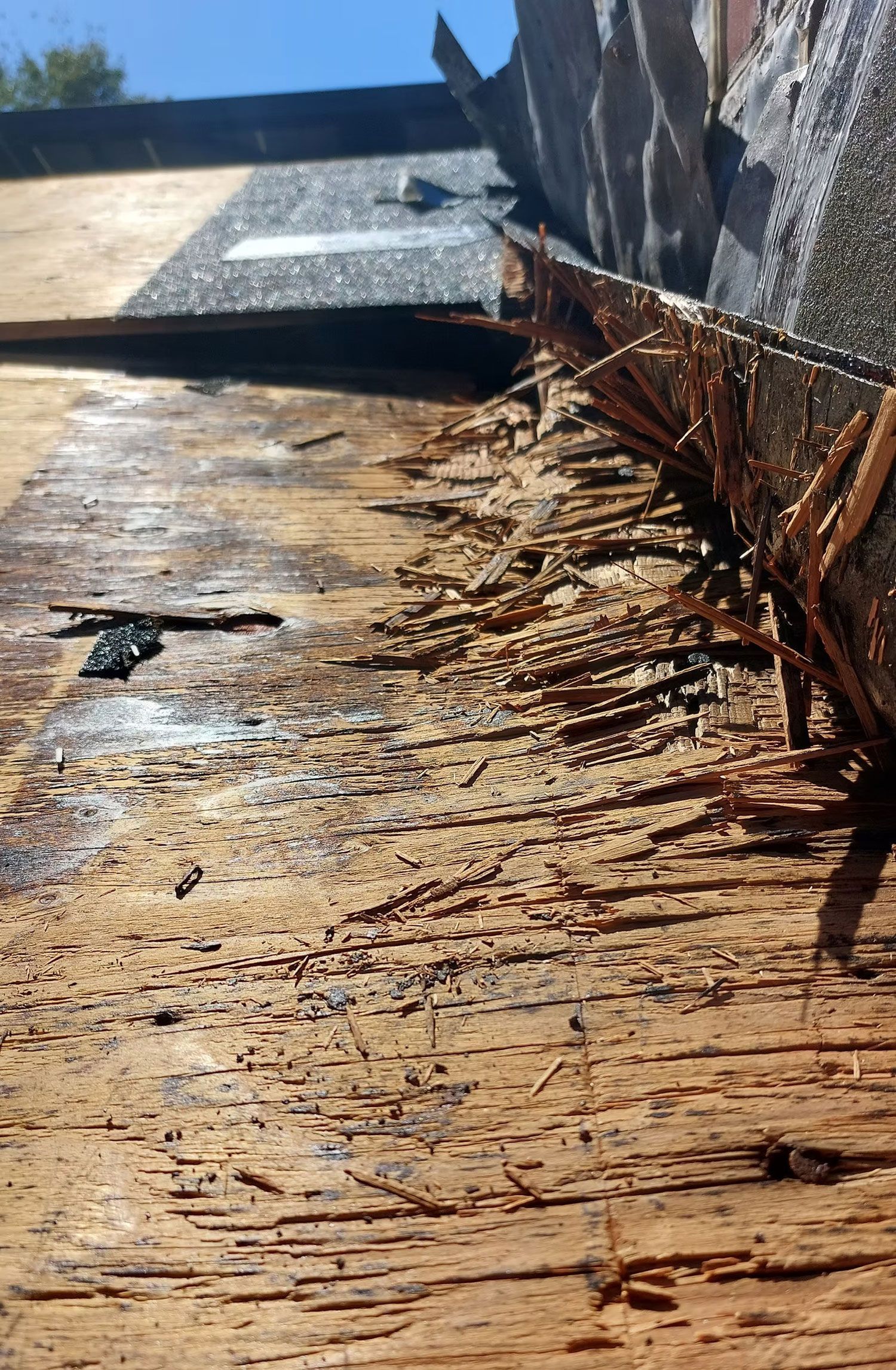 Rusty metal roof corner with water damage and debris along the edge