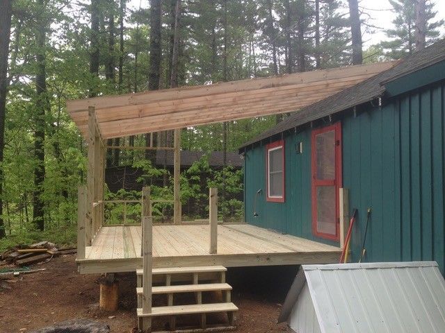 A blue house with a wooden deck in front of it