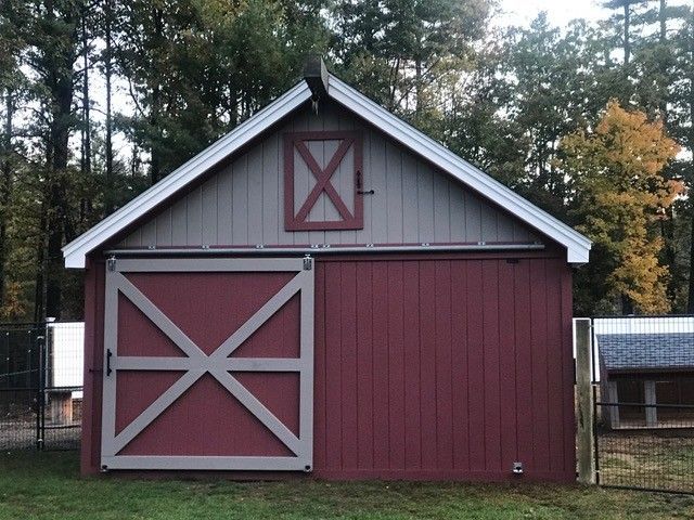 A red barn with a white roof and a sliding barn door