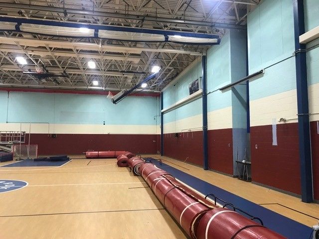 A large indoor gym with a blue and red floor