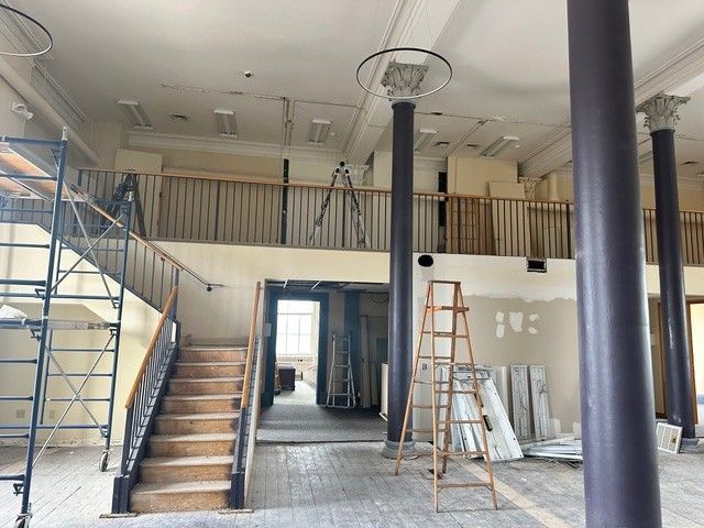 A large empty room with stairs and columns