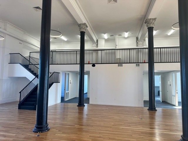 A large empty room with stairs and columns