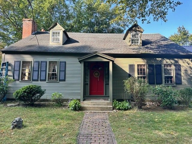 A house with a red door and a brick walkway
