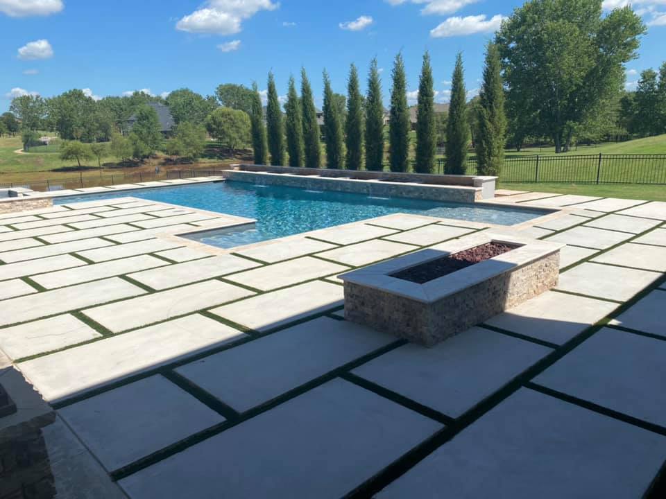 A large swimming pool with a fire pit in the middle