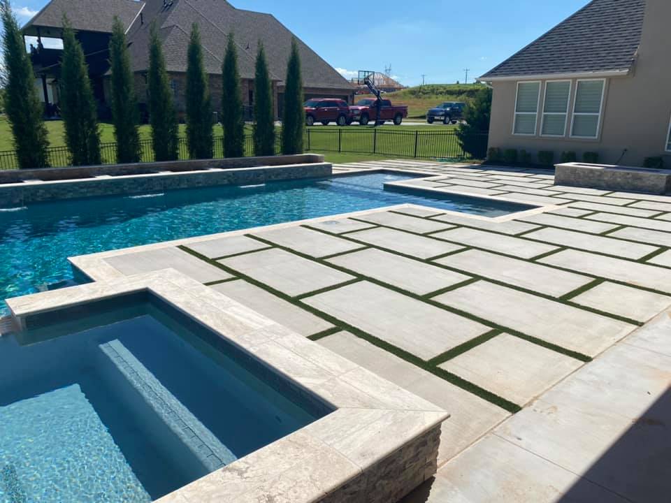 There is a large swimming pool in the backyard of a house.