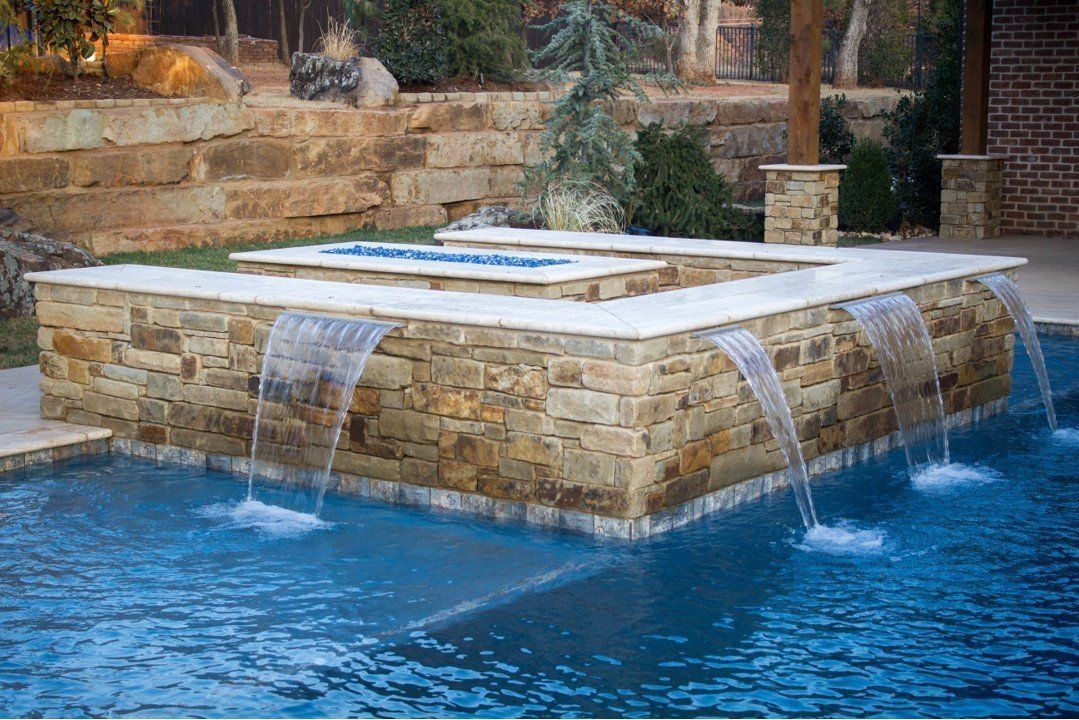 There is a waterfall in the middle of the pool.