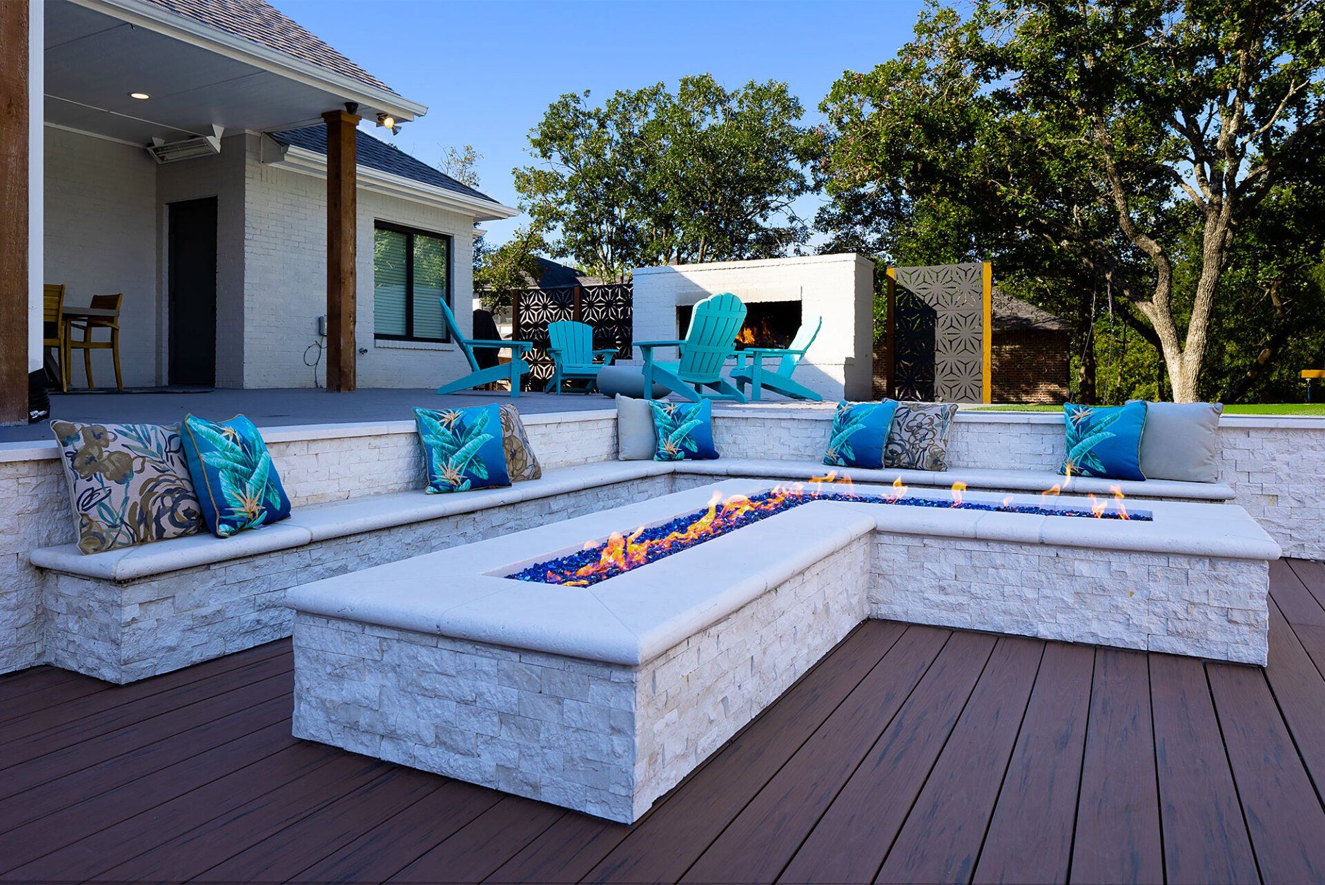 A patio with a fire pit and blue chairs