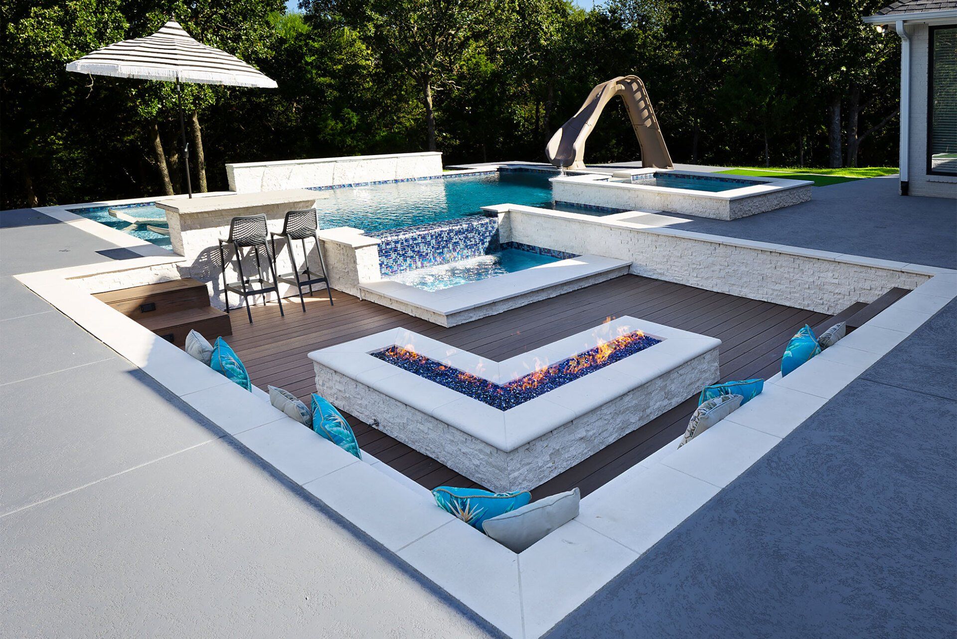 A large swimming pool with a fire pit in the middle