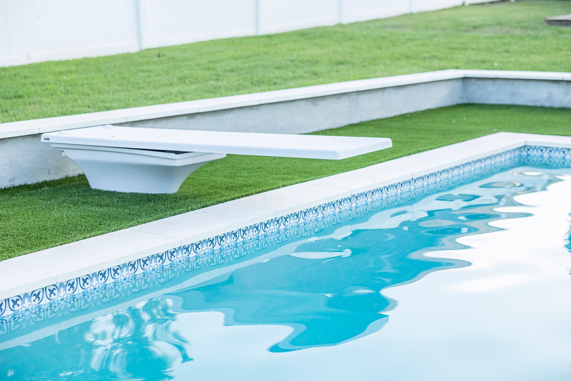 A swimming pool with a diving board in the middle of it.