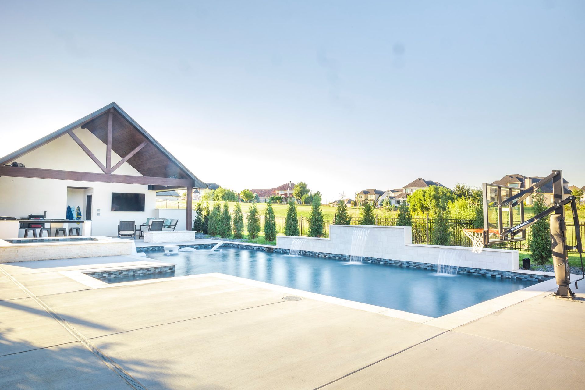 There is a large swimming pool in the backyard of a house.