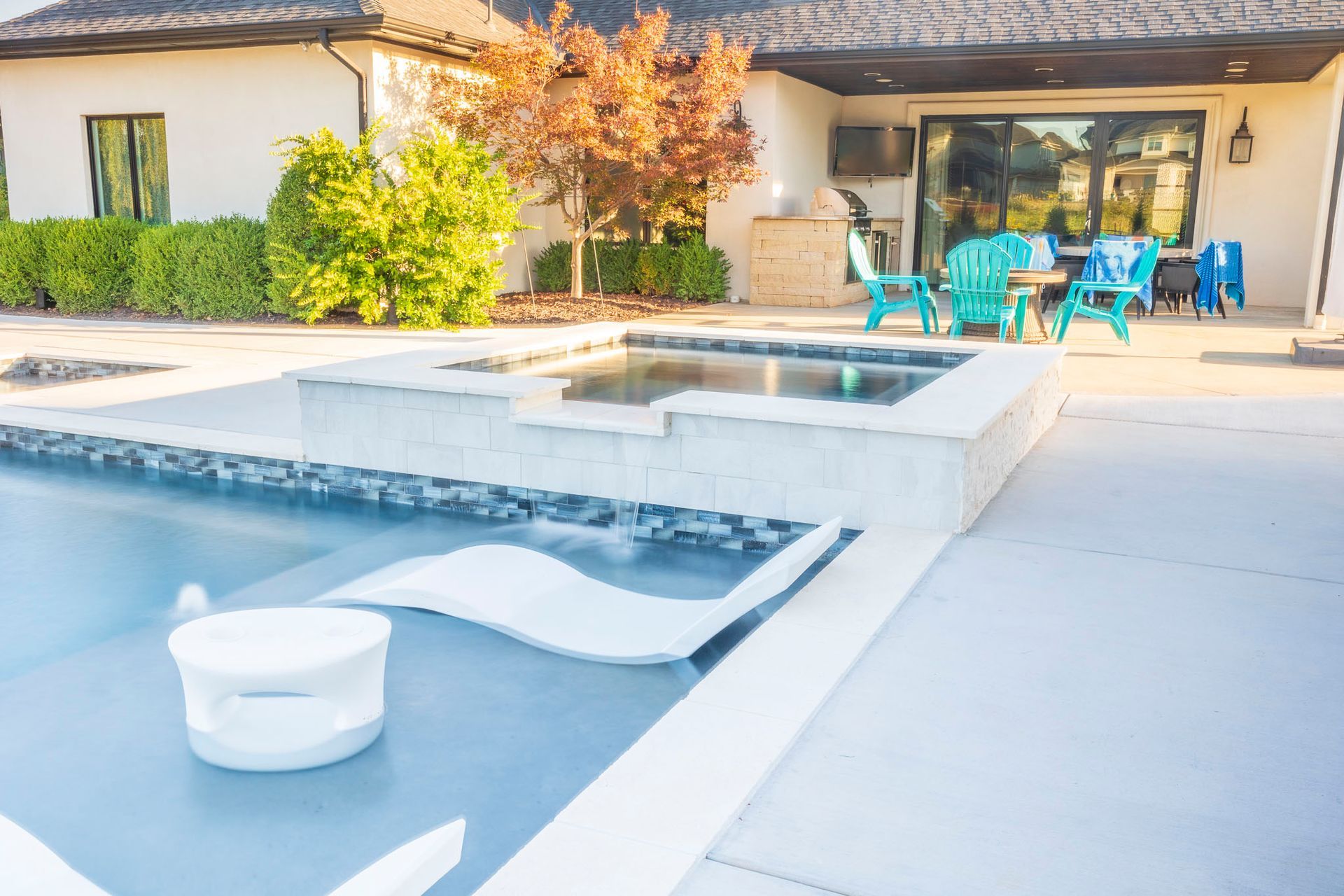 There is a large swimming pool in the backyard of a house.