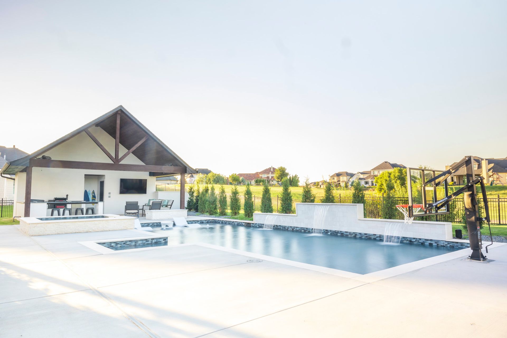 There is a large swimming pool in the backyard of a house.