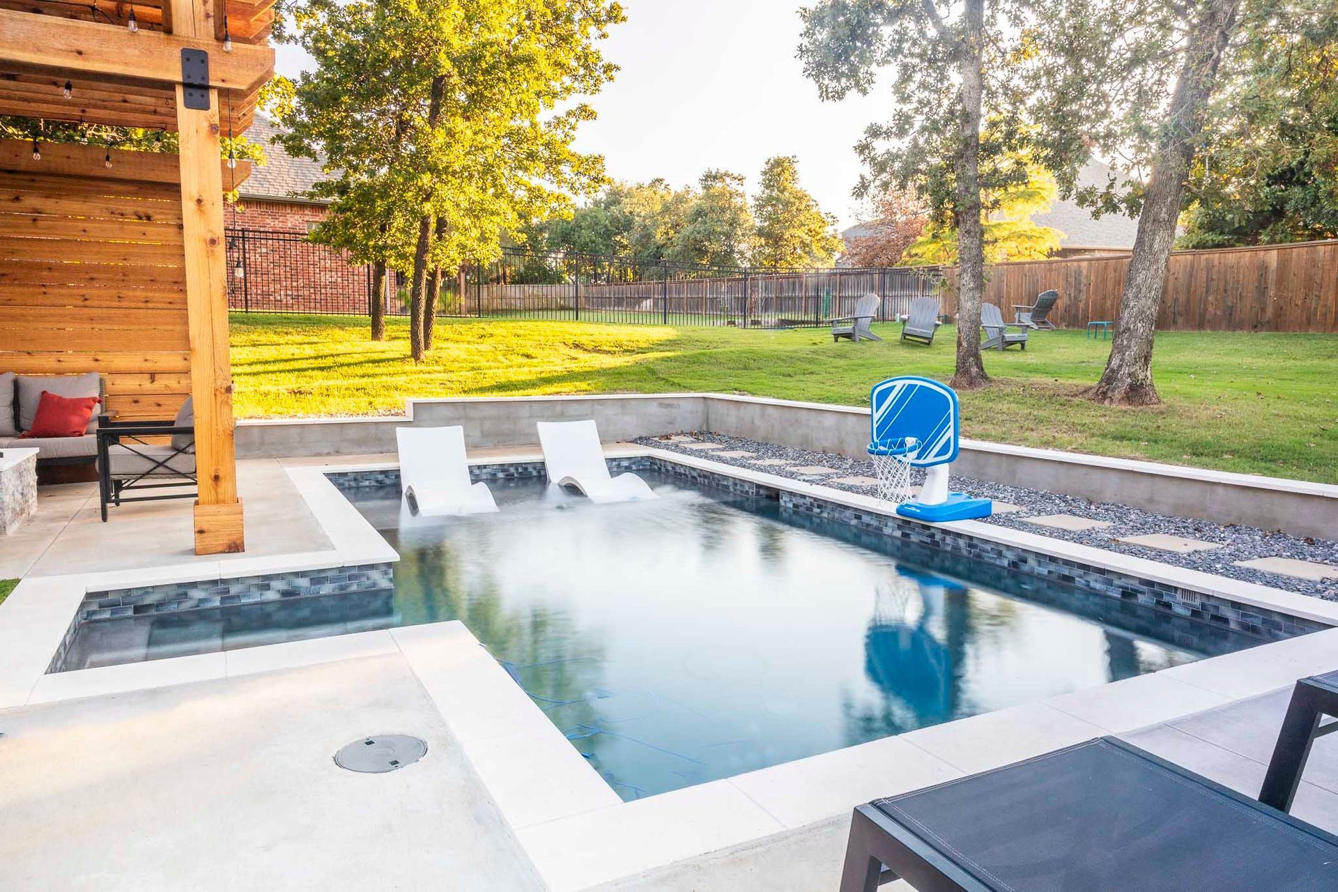 There is a large swimming pool in the backyard of a house.