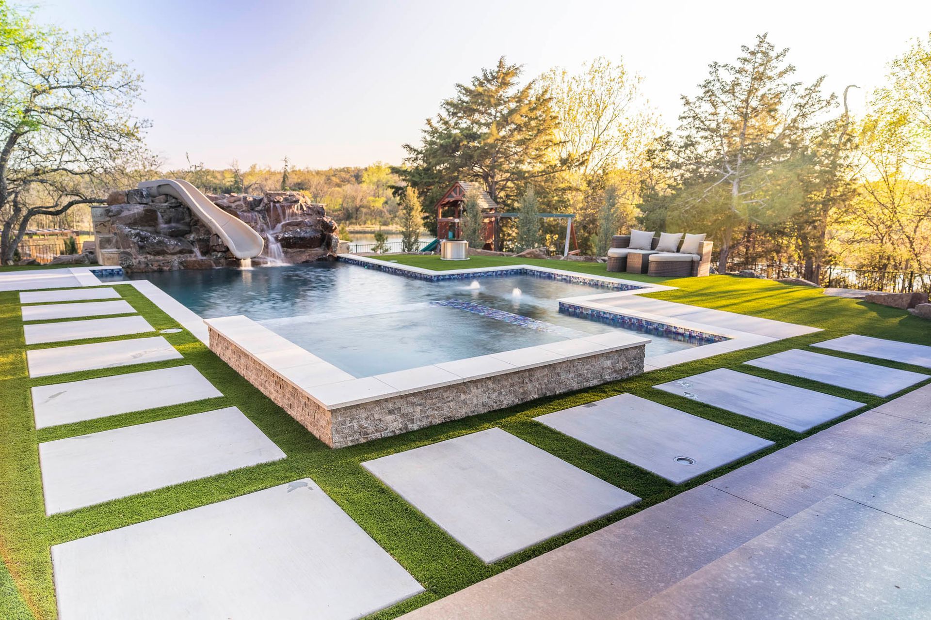 A large swimming pool with a water slide in the backyard.